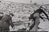 (Four people carrying a man on a stretcher)