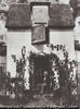 Bayard assis sur le seuil de sa maison.